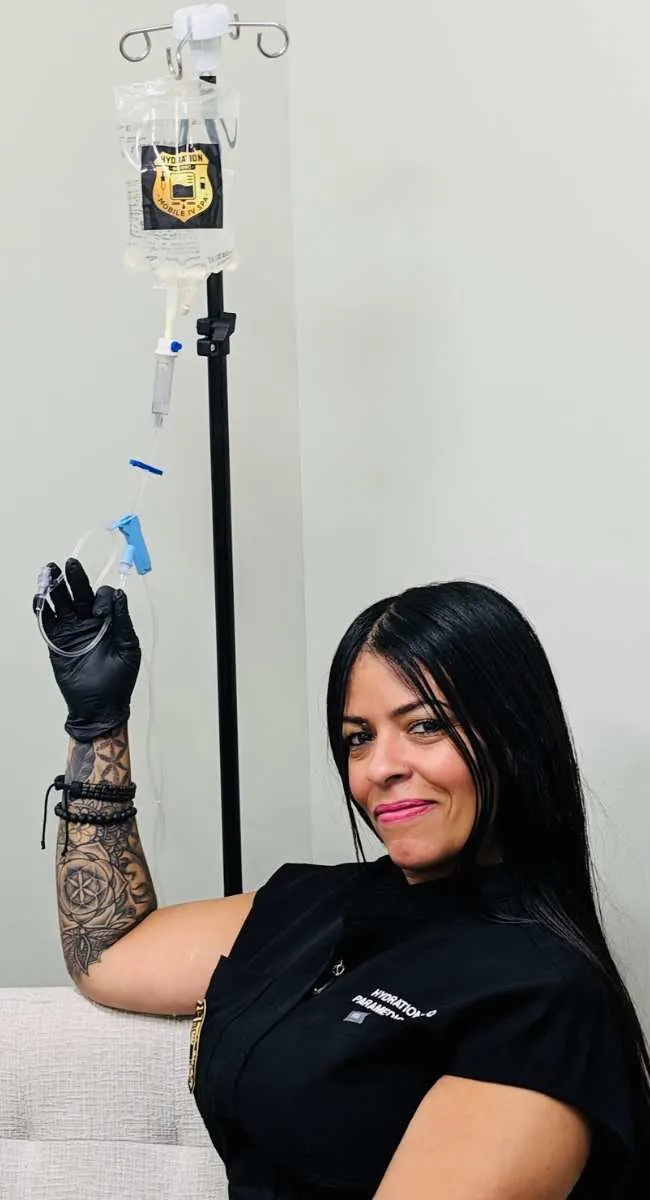 Ivelisse 'Eve' Delgado, paramedic and owner of Hydration Medic, hanging an IV drip bag in the Scarsdale suite
