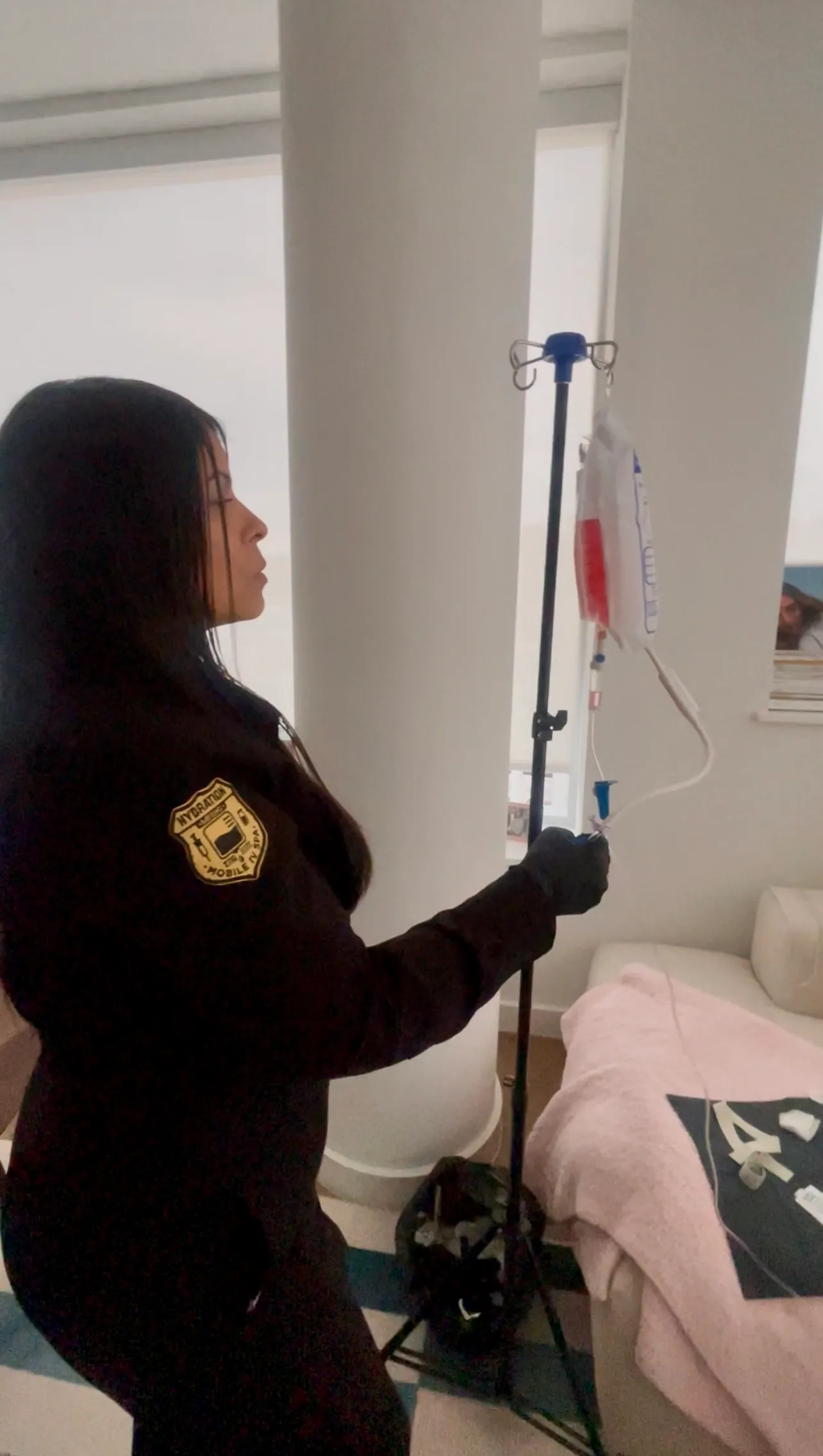 Hydration Medic setting up a mobile IV drip stand in a client’s home
