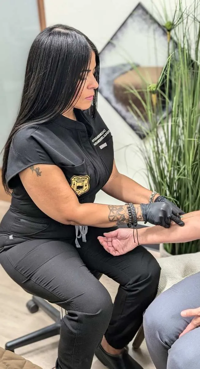 A Hydration Medic paramedic preparing a client's arm for IV drip therapy